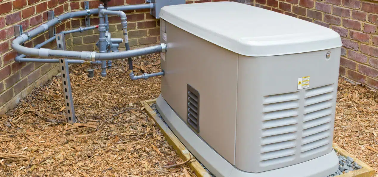 Whole-home generator installed next to a brick home.