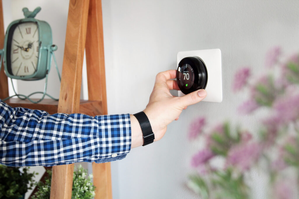 Homeowner adjusting thermostat